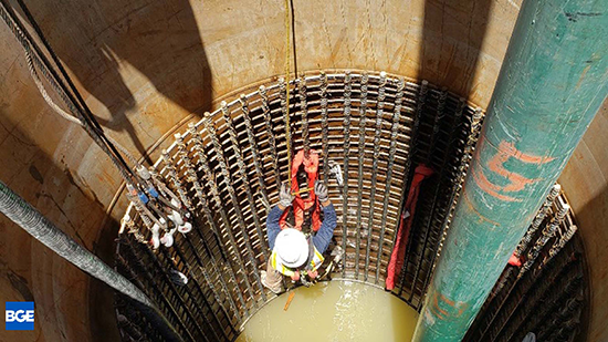 A worker in a harnes inside a shaft.
